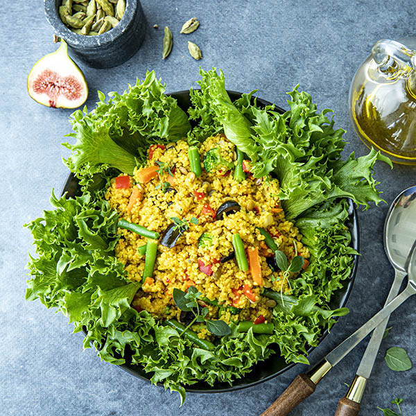 Couscouspytt anrettet i skål med crispisalat og oliven, men olje og fiken ved siden av