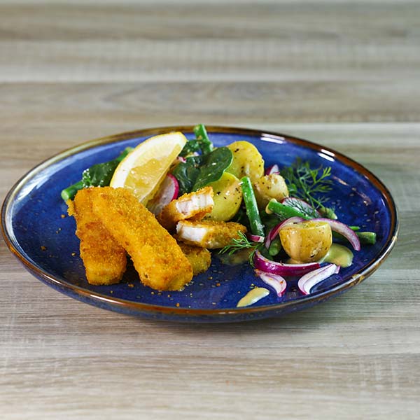 Tallerken lagt opp med fiskepinner og potetsalat av småpotet og aspargesbønner, reddik og rødløk