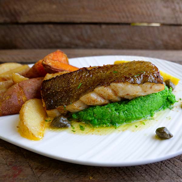 Produktoppskrift: Stekt torskerygg med skinn på seng av ertepure med stekte potetbåter og kaperssmør.